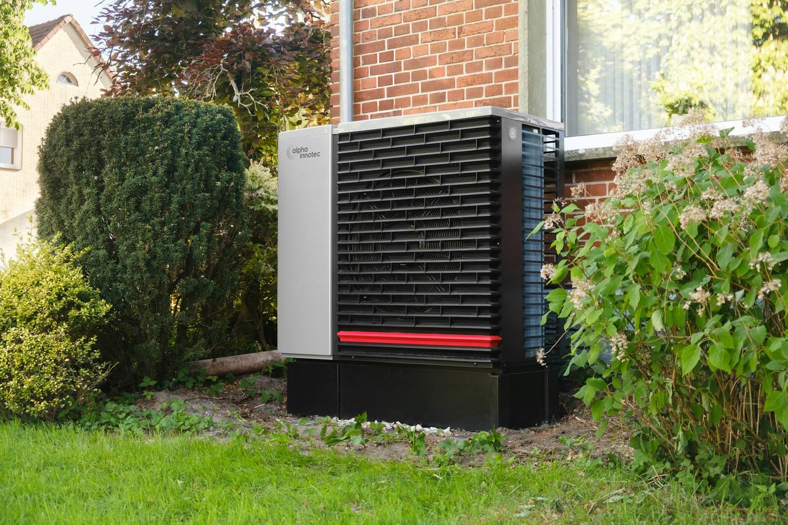 Pompe à chaleur air/eau installée dans le jardin d'une maison